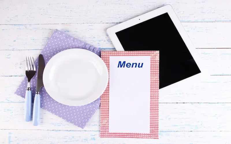 Photo d’une assiette, d’un menu et d’une tabelle sur une table Photo d'une assiette, d'un menu et d'une tabelle sur une table