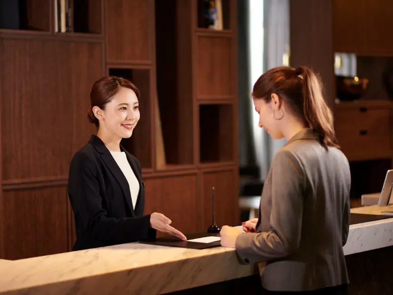 Concierge gérant une réclamation client en anglais au lobby de l'hôtel